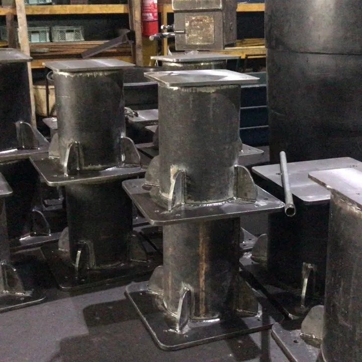 Welded steel pipe columns with gusseted square base plates on a workshop floor
